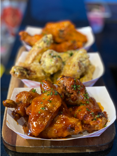 Three baskets of wings with different sauces.